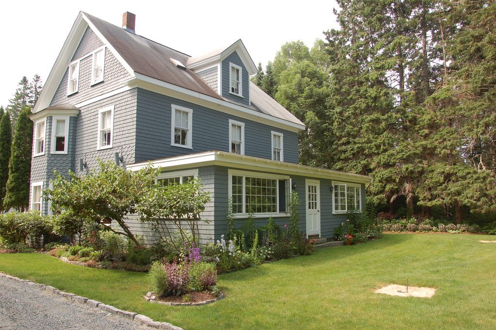 Blue-grey family home with a green lawn and established gardens