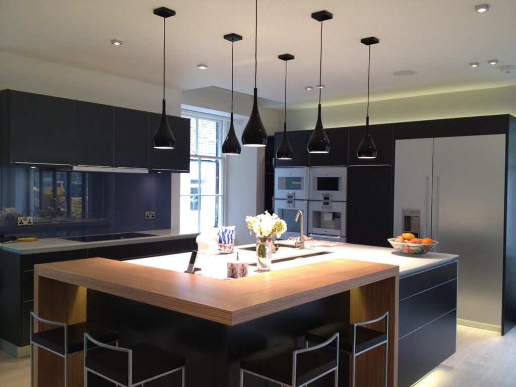 Modern kitchen with a large island, pendant lights and dark cabinetry